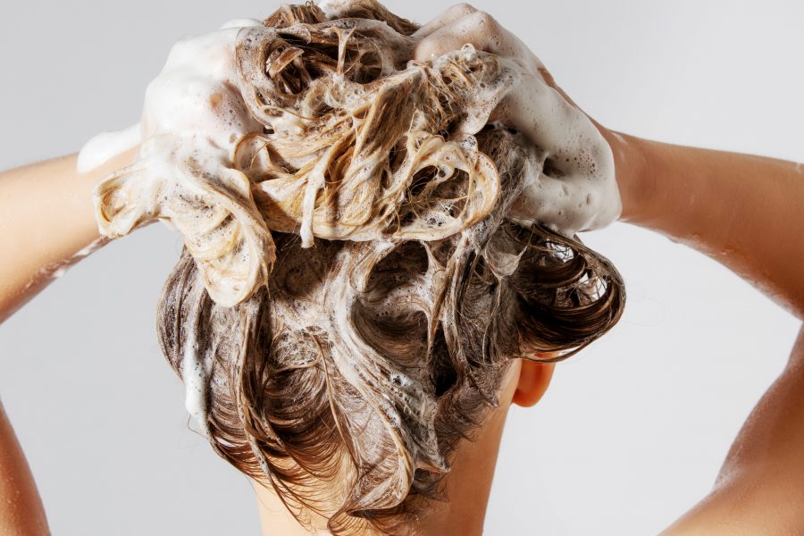 Woman washing her blond hair.