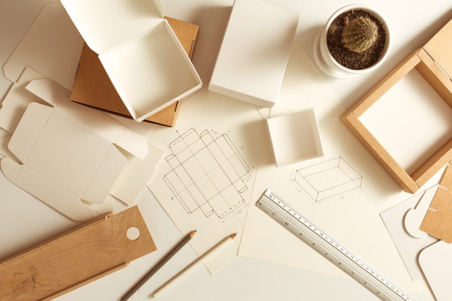 Workplace of the designer of cardboard packaging. Sketching paper boxes.