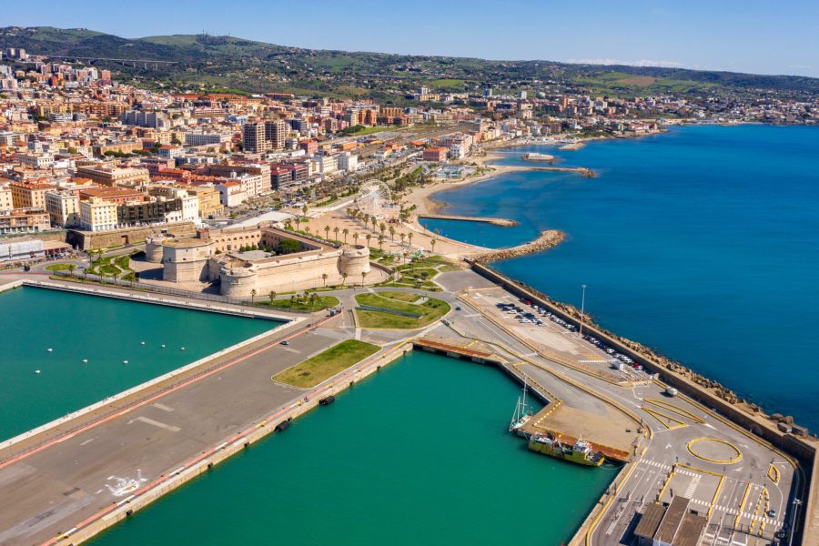 Aerial view of Fort Michelangelo, located in the port of Civitavecchia, in the Metropolitan City of Rome, Italy. On the city's waterfront is a park and a large white Ferris wheel.