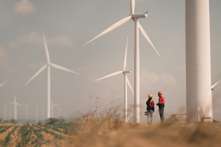 Young man and woman maintenance engineer team. two engineer operate wind turbine. Engineer and worker discussing on a wind turbine farm. Wind Turbine. Maintenance Workers. renewable energies..