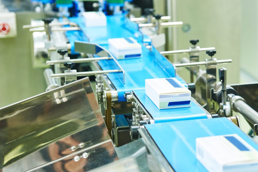 pharmaceutical packing production line conveyer at manufacture pharmacy factory. Authentic shot in challenging conditions. maybe little blurred