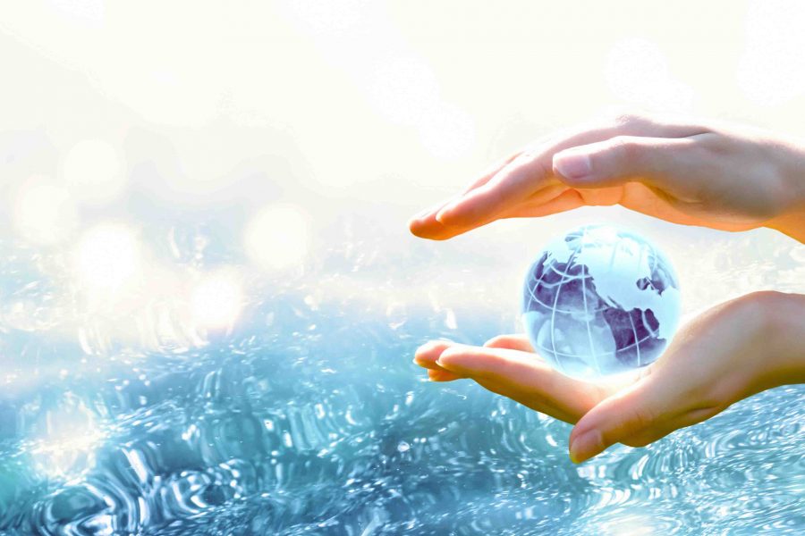 Card for World Oceans Day or Water Day. Blue planet crystal glass globe in human hand on pure sea background. Saving environment, save, protect clean planet and ecology, sustainable lifestyle concept.