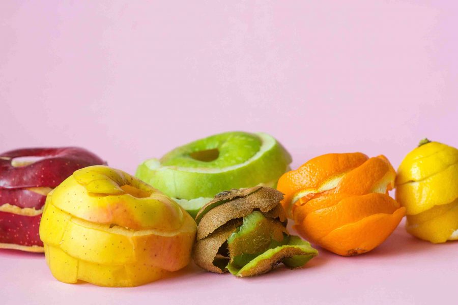 kiwi, orange, lemon and red, green, yellow apple peels on pink b