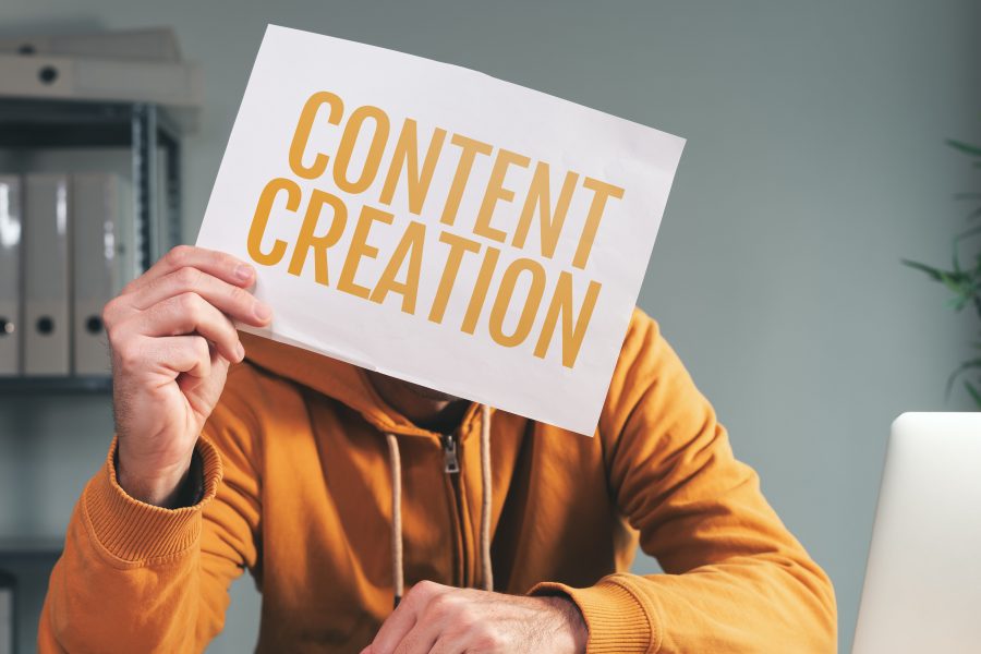 Content creation, man holding paper in front of his face in home office interior, selective focus